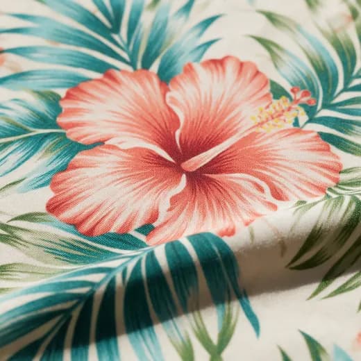 Close view of a coral hibiscus printed on shirt fabric
